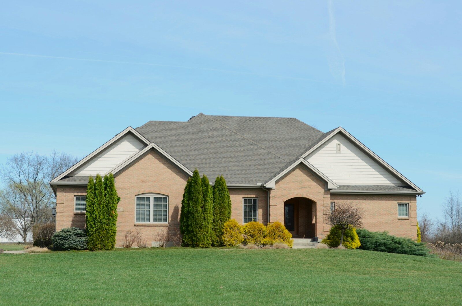 A suburban brick house with a well-kept lawn.